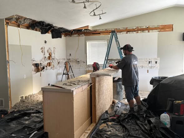 Man demoing kitchen. 