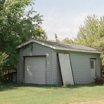 Small gray shed on grass.